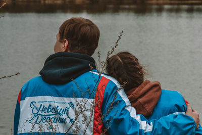 Rear view of friends against water