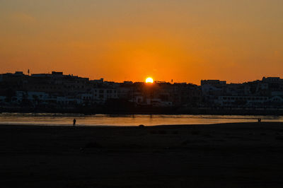 Silhouette buildings against sky during sunset