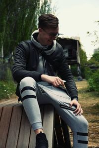 Full length of young man sitting on table