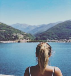 Rear view of woman looking at lake and mountains