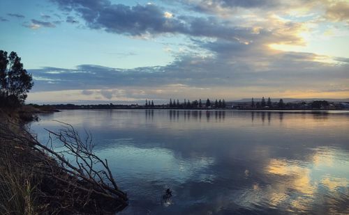 Scenic view of river against cloudy sky