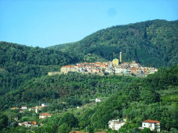 Houses on townscape by mountain against sky