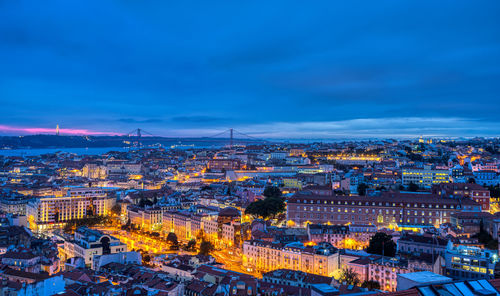 Lisbon in portugal at night with the sanctuary of christ the king and the 25 de abril bridge 