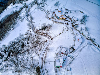 High angle view of snow on road amidst trees