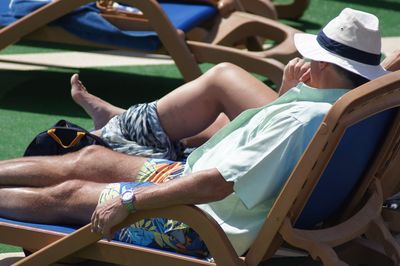 Man relaxing on lounge chair during sunny day