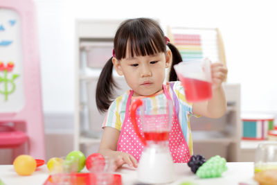 Young girl pretend play food preparing at home