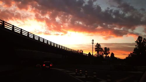 Silhouette bridge against sky during sunset