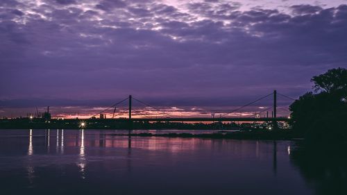 Bridge over river against sky during sunset