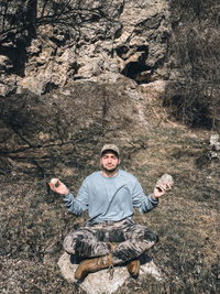 Young man sitting on rock