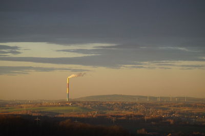 Smoke emitting from chimney against sky