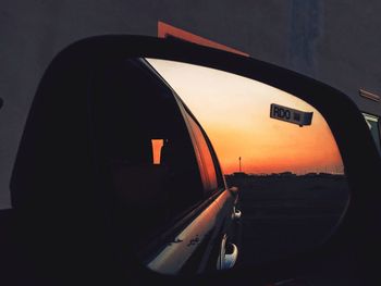 Close-up of airplane against sky during sunset