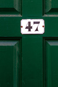 Close-up of sign on green door