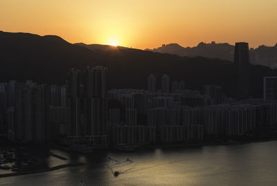 Buildings in city against sky during sunset