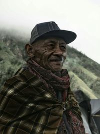 Portrait of man standing by tree against sky