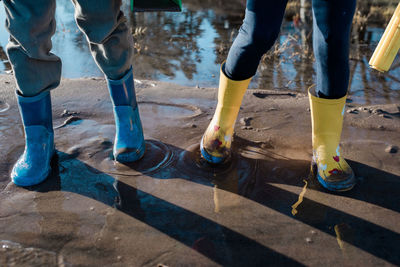 Children's rain boots playing in the sand and sea in sweden