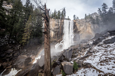 Scenic view of waterfall against sky during winter