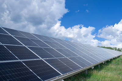 Solar panels on field against sky