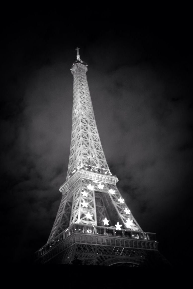 low angle view, built structure, tower, architecture, international landmark, tall - high, famous place, eiffel tower, sky, travel destinations, capital cities, tourism, travel, culture, history, building exterior, architectural feature, metal, cloud - sky, communications tower