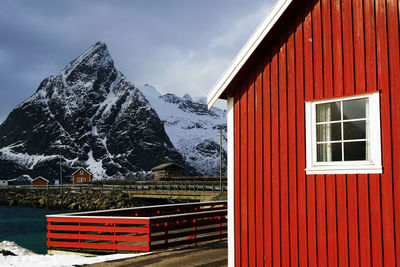 Snow covered house and mountains against sky