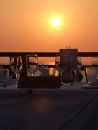 Restaurant by sea against sky during sunset