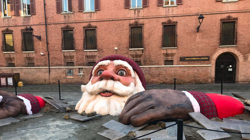 Full length of man sculpture on street against building