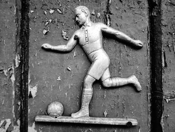 Close-up of old statue against wall