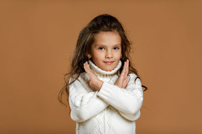 Portrait of young woman against yellow background