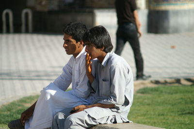 Side view of couple sitting outdoors