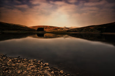 Scenic view of lake against dramatic sky