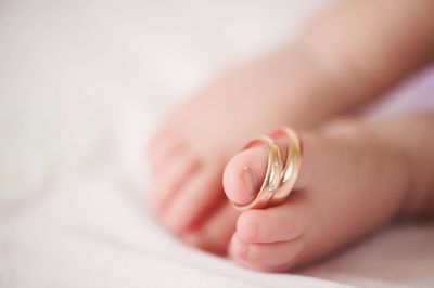 Low section of baby with rings on bed