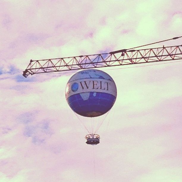 low angle view, sky, cloud - sky, transportation, cloudy, lighting equipment, communication, amusement park, outdoors, cloud, illuminated, dusk, no people, hanging, amusement park ride, day, built structure, mid-air, fun, travel