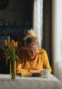 Woman sitting on table at home