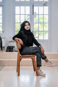 Young woman sitting on sofa at home