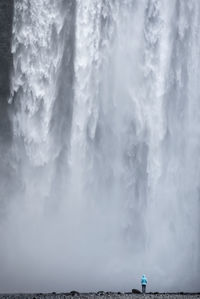 Person standing against waterfall