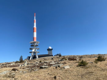 Low angle view of communications tower against clear blue sky