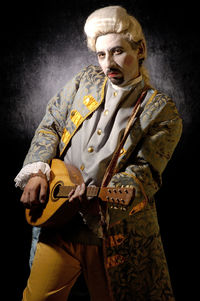 Portrait of man wearing mask against black background