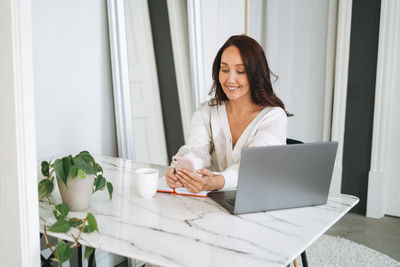 Young woman using laptop at home