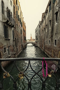 Canal amidst city against clear sky