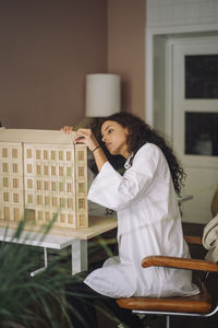 Portrait of young woman sitting at home