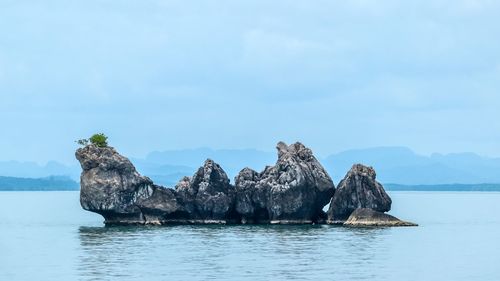 Scenic view of rocks in sea against sky