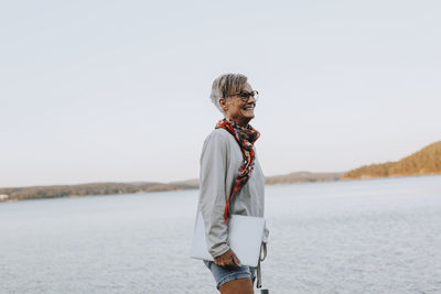 Woman at sea holding laptop