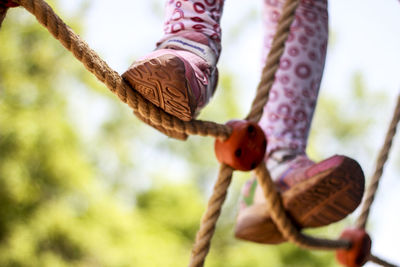 Low angle view of hand holding rope
