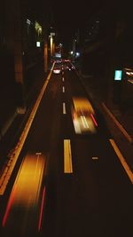 Road passing through illuminated city at night