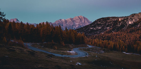 Scenic view of road by mountains against sky