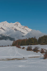 Scenic view of snowcapped mountains against clear blue sky