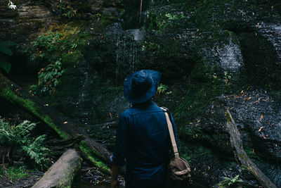 Rear view of boy standing in forest