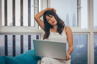 Young woman using mobile phone at home