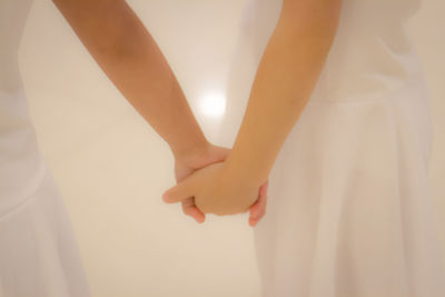 Midsection of women holding hands