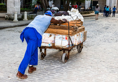 Rear view of people walking on street in city