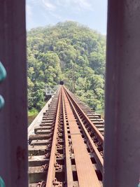 Railroad tracks by trees against sky